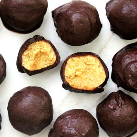 Overhead horizontal view of Gluten-Free Vegan Healthy Peanut Butter Eggs (aka Reese's Vegan Peanut Butter Eggs) showing the inside of one on a white marble surface