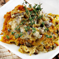 Gluten-Free Vegan Creamy Mushroom Lasagna on a white plate on a wooden surface.