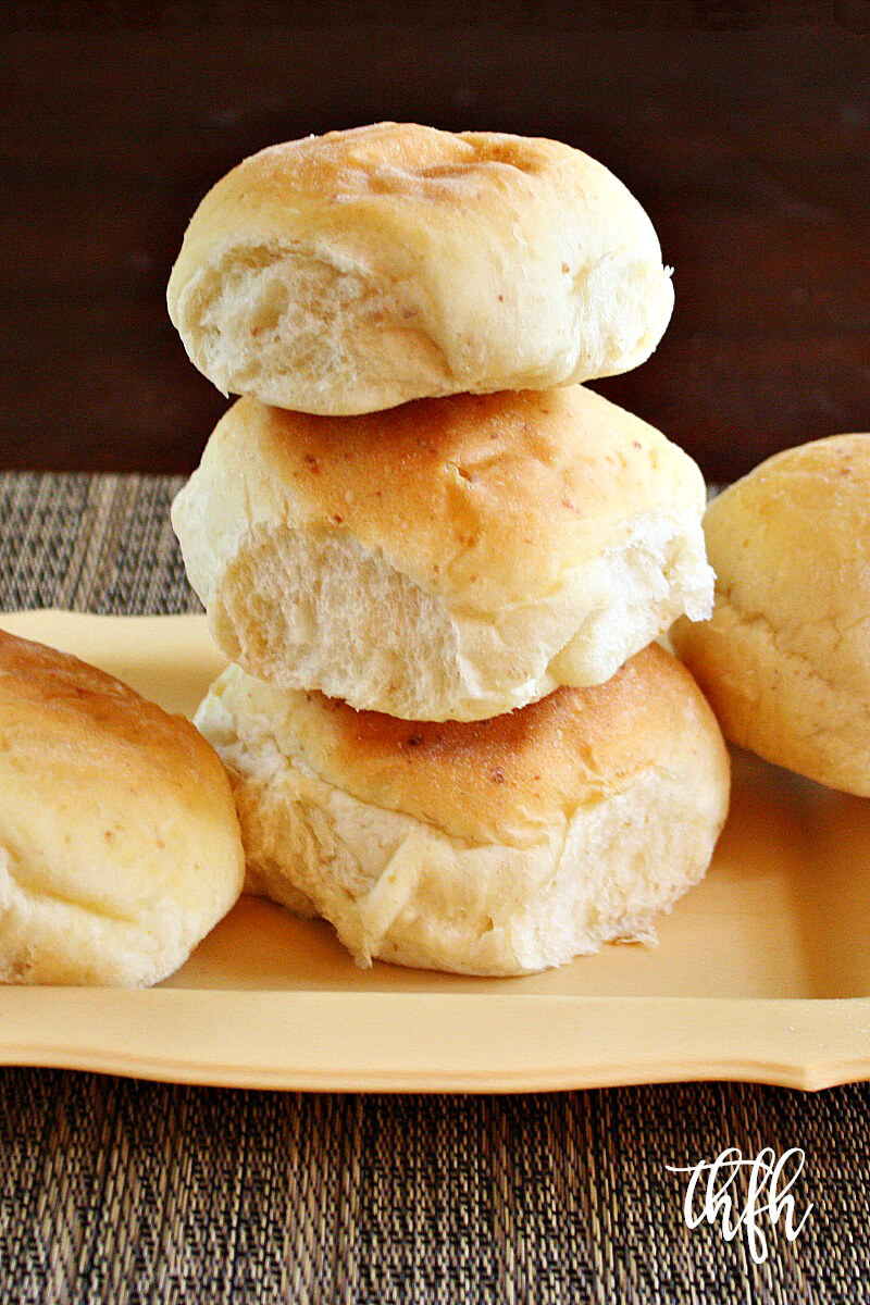 Vertical view of a stack of The BEST Homemade Vegan Egg-Free "Hamburger" Buns on a yellow plate