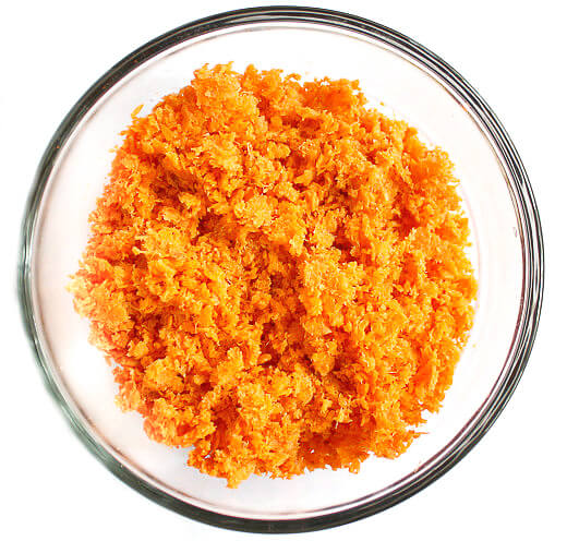 Overhead image of a glass bowl of carrot pulp to make Gluten-Free Vegan Raw Carrot Pulp and Flax Seed Crackers