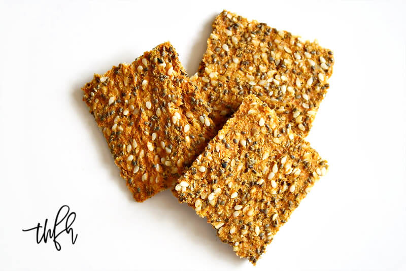 Overhead image of three Gluten-Free Vegan Raw Carrot Pulp and Flax Seed Crackers on a white background