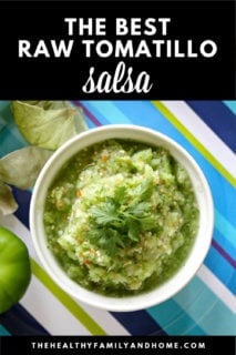 Overhead image of a white bowl filled with The BEST Homemade Raw Tomatillo Salsa Verde on a blue striped plate with text overlay