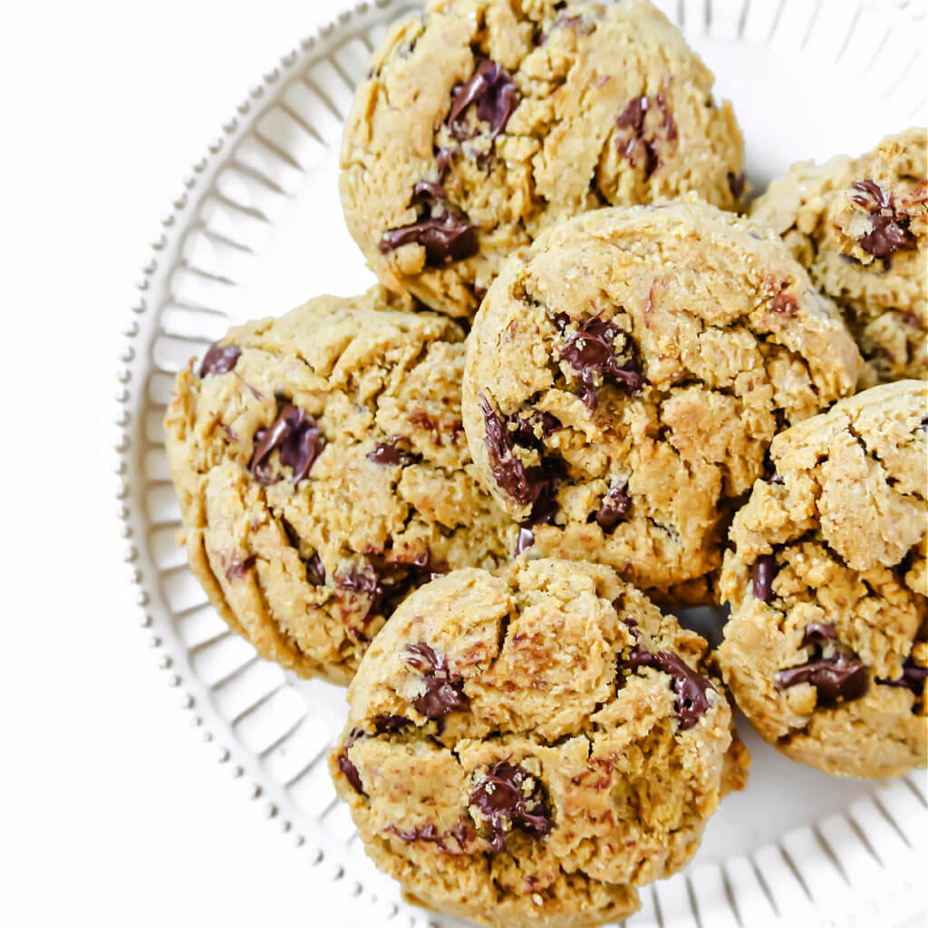 Overhead square image of a decorative white plate filled with pumpkin chocolate chip cookies