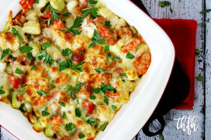 Overhead image of a casserole dish of Spicy Vegan Italian Cucuzza Squash Casserole Bake on a white wooden surface