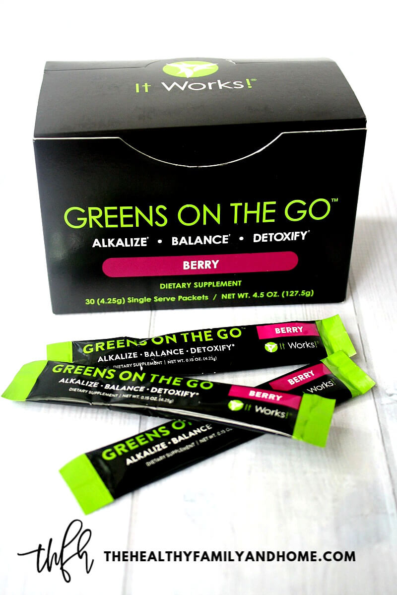 A box of "Greens On The Go" Berry by It Works! on a white wooden surface