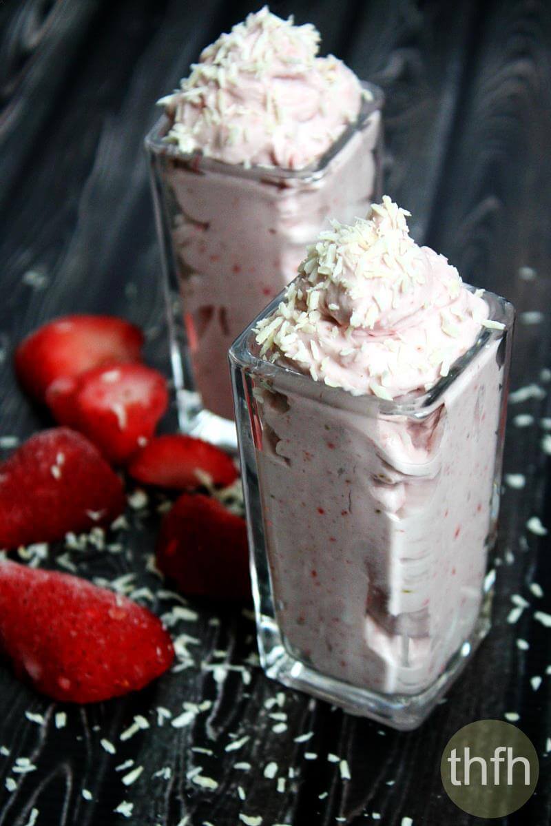 Two glass cups with Clean Eating Vegan Strawberry Mousse with fresh strawberries on the side