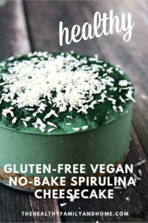 A whole 6-inch Gluten-Free Vegan No-Bake Spirulina Cheesecake sprinkled with shredded coconut on a weathered wooden surface with text overlay