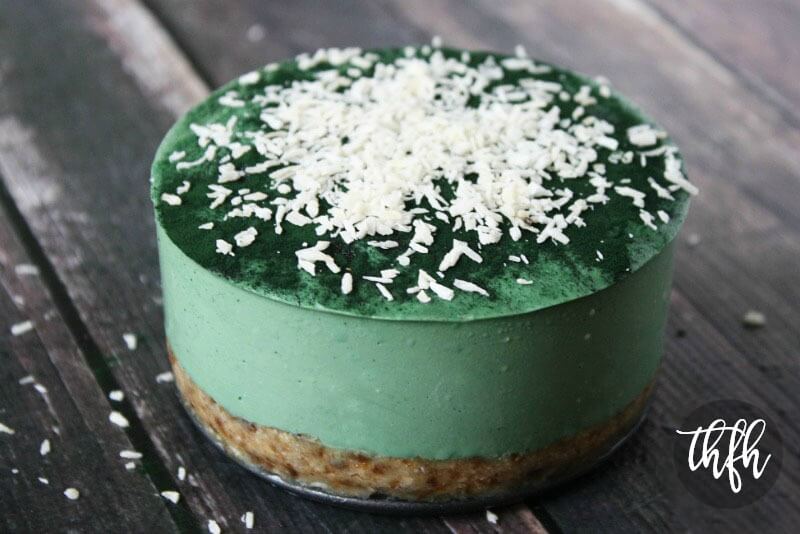 Image of a 6-inch uncut Gluten-Free Vegan Raw No-Bake Spirulina Cheesecake on a weathered wooden surface