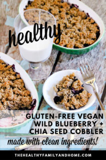 Vertical image of two green baking dishes side by side filled with blueberry cobbler on a weathered wood surface with text overlay