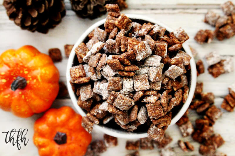 Overhead image of a white bowl overflowing with Gluten-Free Vegan Pumpkin Spice "Puppy Chow" Muddy Buddies with pumpkins in the background