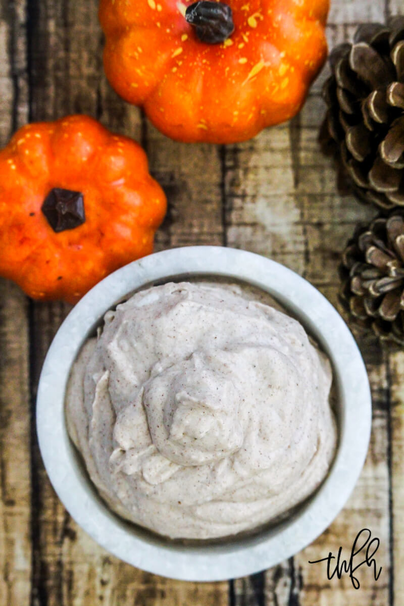Overhead image of a small white marble bowl of The BEST Vegan Pumpkin Spice Mousse with Fall decorations surrounding it