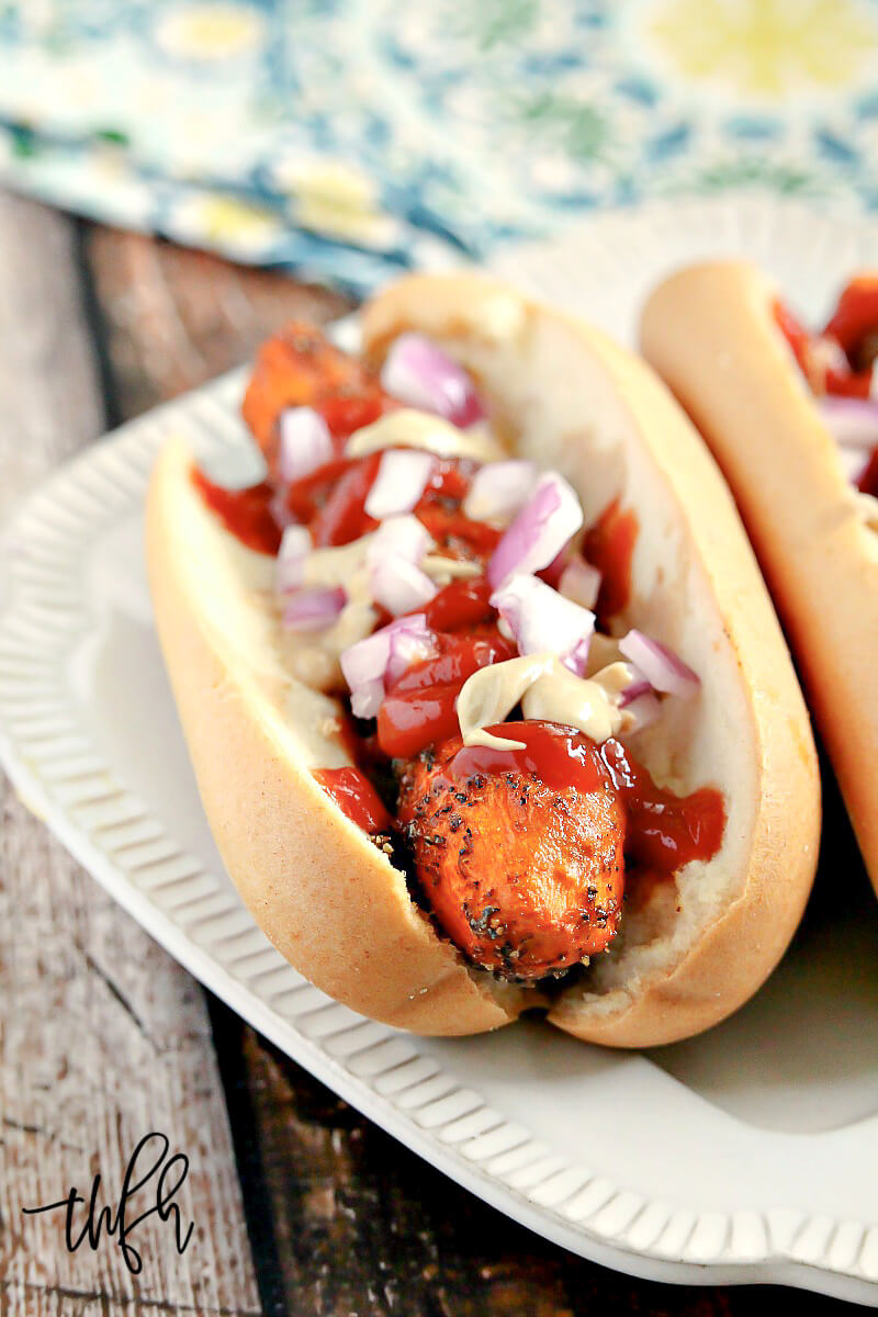 Vertical image of two Gluten-Free Vegan Healthy Carrot "Hot Dogs" on a cream plate on a wooden background 