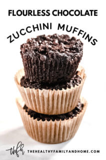 Stack of three Gluten-Free Vegan Flourless Chocolate Zucchini Muffins in paper muffin cups on a white surface