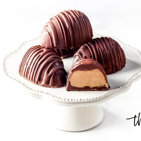 4 Gluten-Free Vegan Healthy Reese's Peanut Butter Eggs on a small white pedestal on a white background