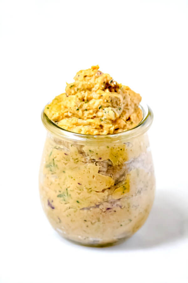 Vertical view of Gluten-Free Vegan Sweet Potato and Cilantro Dip in a glass jar on a white surface