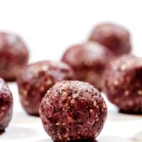 Vertical view of Gluten-Free Vegan Healthy No-Bake Triple Seed Energy Balls on a white surface