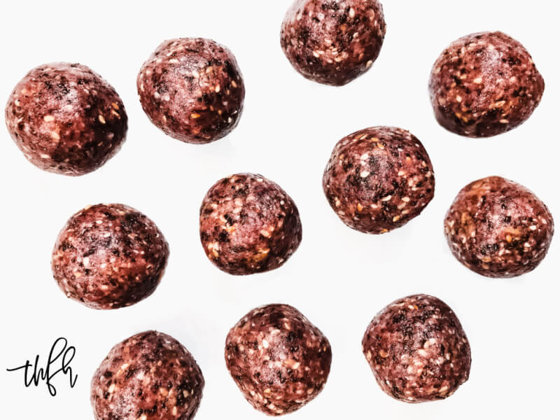 Overhead view of numerous Gluten-Free Vegan Healthy Triple Seed Energy Balls on a solid white surface