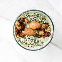 Overhead view of a glass of Gluten-Free Vegan Mango and Hemp Seed Smoothie on a white marble surface