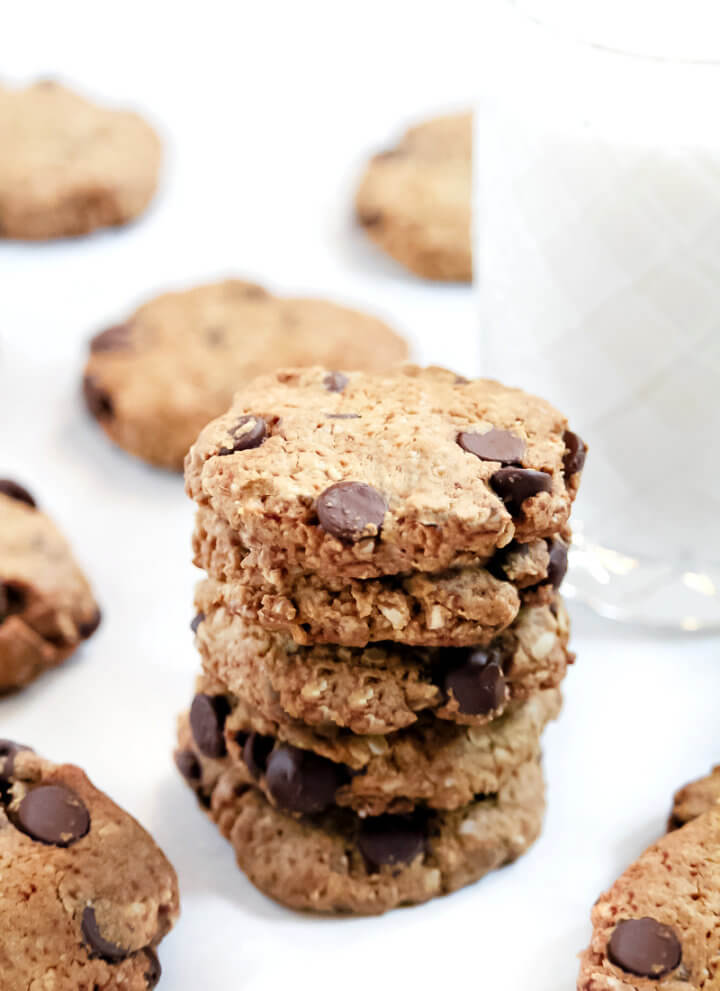 Vertical image of a stack of The BEST Gluten-Free Vegan Chocolate Chip Oatmeal Cookies on a white surface