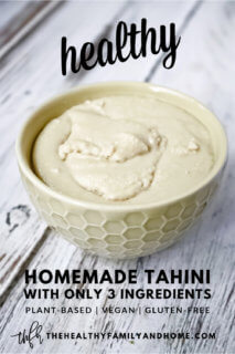 Vertical image of a cream bowl filled with The BEST Homemade Tahini on a weathered wooden surface with text overlay