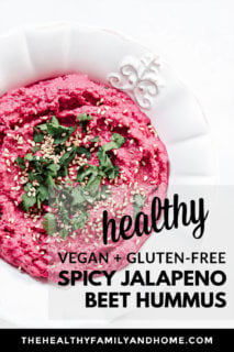 Overhead view of a decorative white bowl filled with The BEST Gluten-Free Vegan Spicy Jalapeno Beet Hummus on a solid white background with text overlay