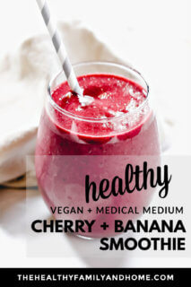 A close up image of a glass filled with The BEST Vegan Cherry Banana Smoothie on a white background with text overlay