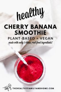 An overhead image of the top of a glass of The BEST Vegan Cherry Banana Smoothie with a straw sticking out of the glass with a cream napkin next to it with text overlay