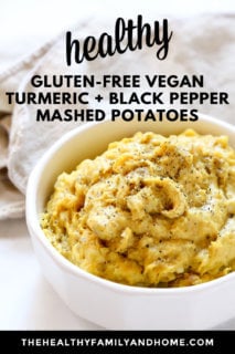 Close-up image of a white bowl filled with Gluten-Free Vegan Turmeric and Black Pepper Mashed Potatoes next to a cream cloth napkin with text overlay